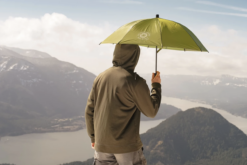 Hiker holding Rain Walker SUL Umbrella on mountain overlooking lake