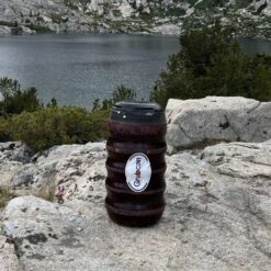 Grub Can Bear Canister on a rock by a mountain lake