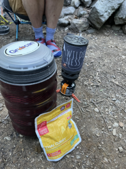Camp kitchen setup featuring Grubcan Bear Canister
